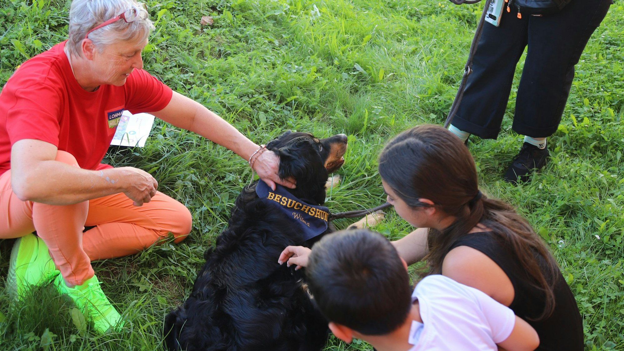 Manu Gardeweg (l.) und Kinder streicheln einen Hund.
