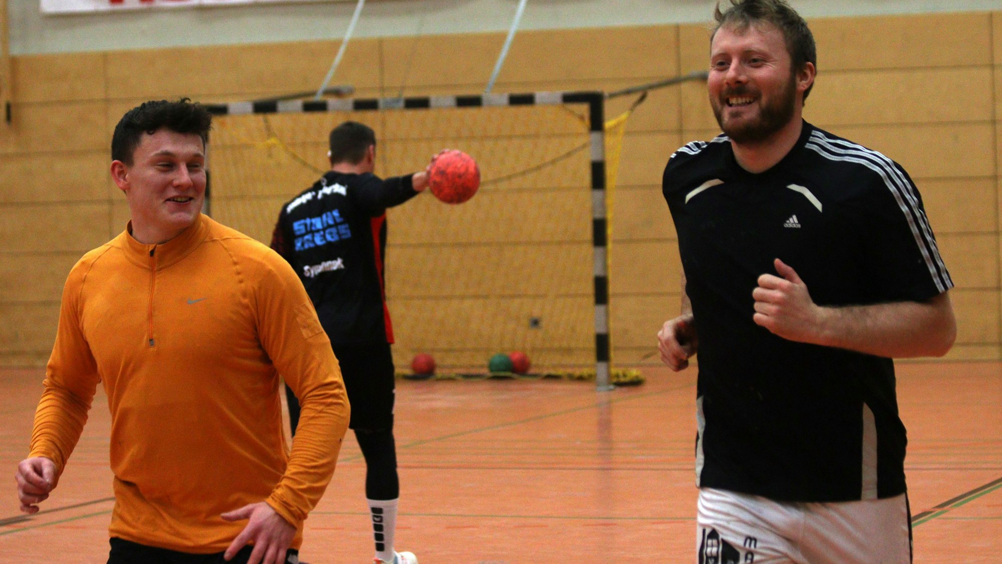 Zwei Handballer haben beim Aufwärmen Spaß.