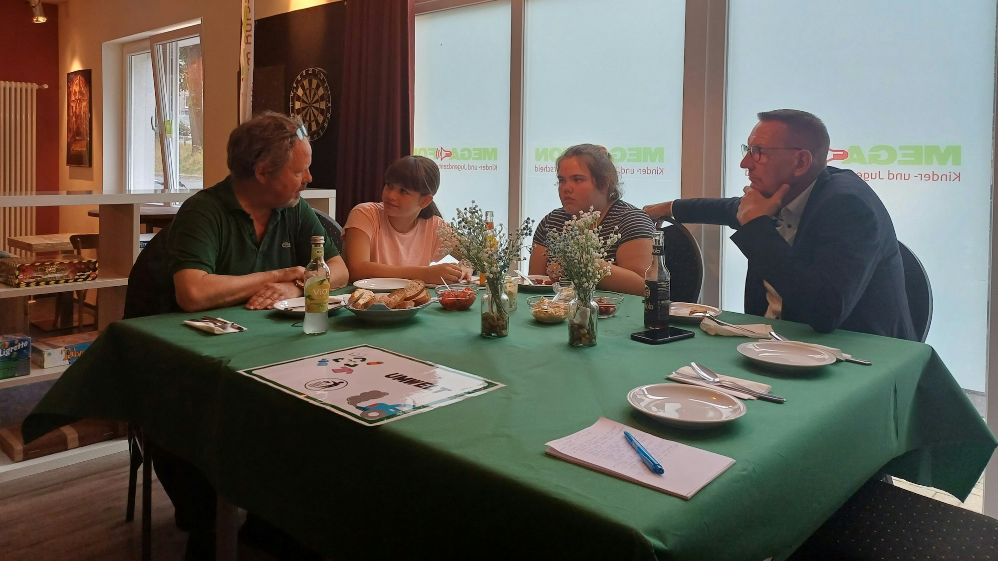 Am Umwelt-Tisch wird während der Vorspeise über Klimakleber diskutiert.