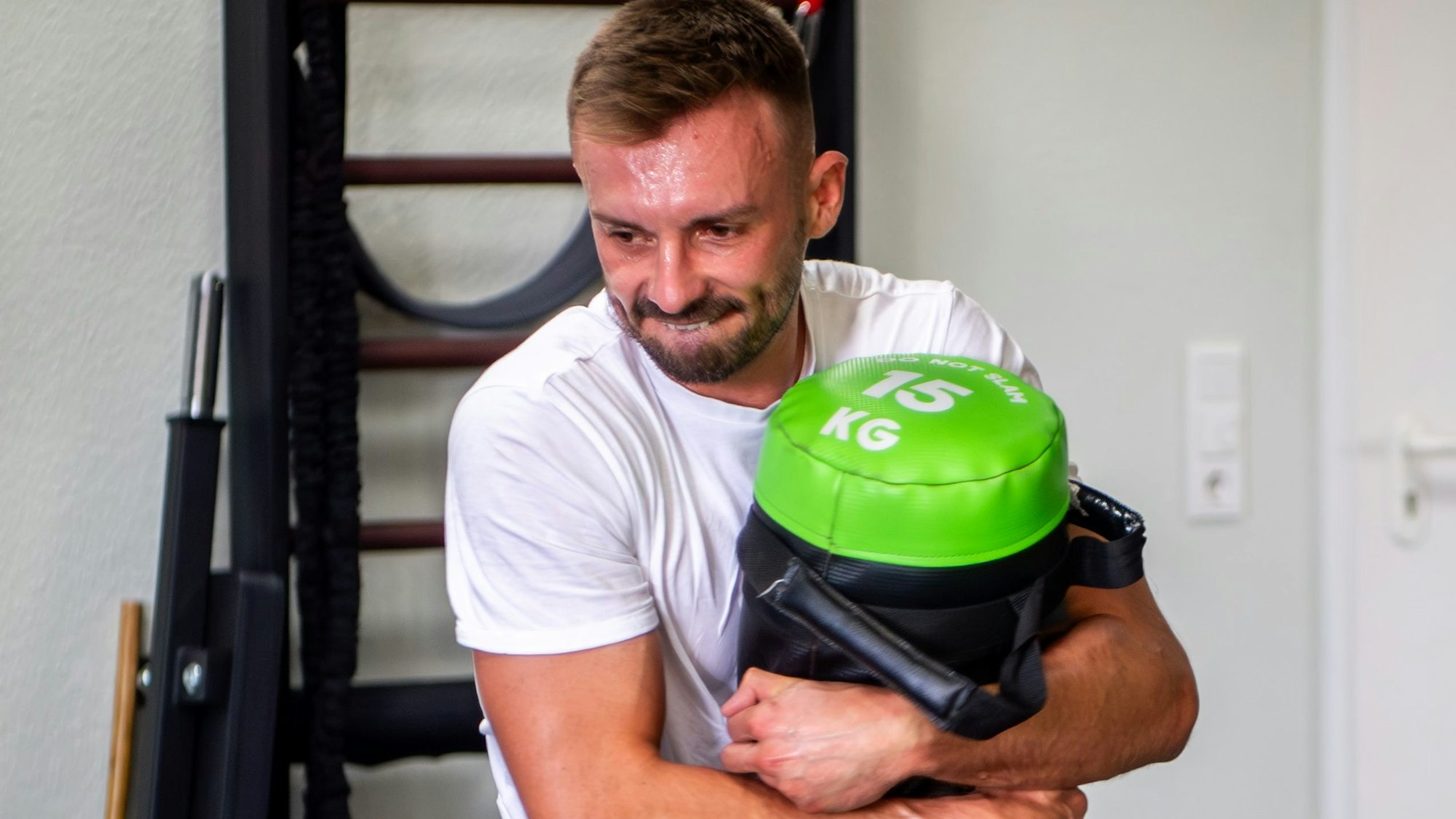 Das Bild zeigt Robin Ritz, der einen 15 Kilo schweren Sack trägt.