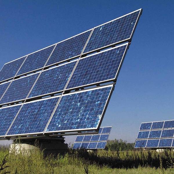 Elemente einer Photovoltaik-Anlage stehen auf einer Wiese.