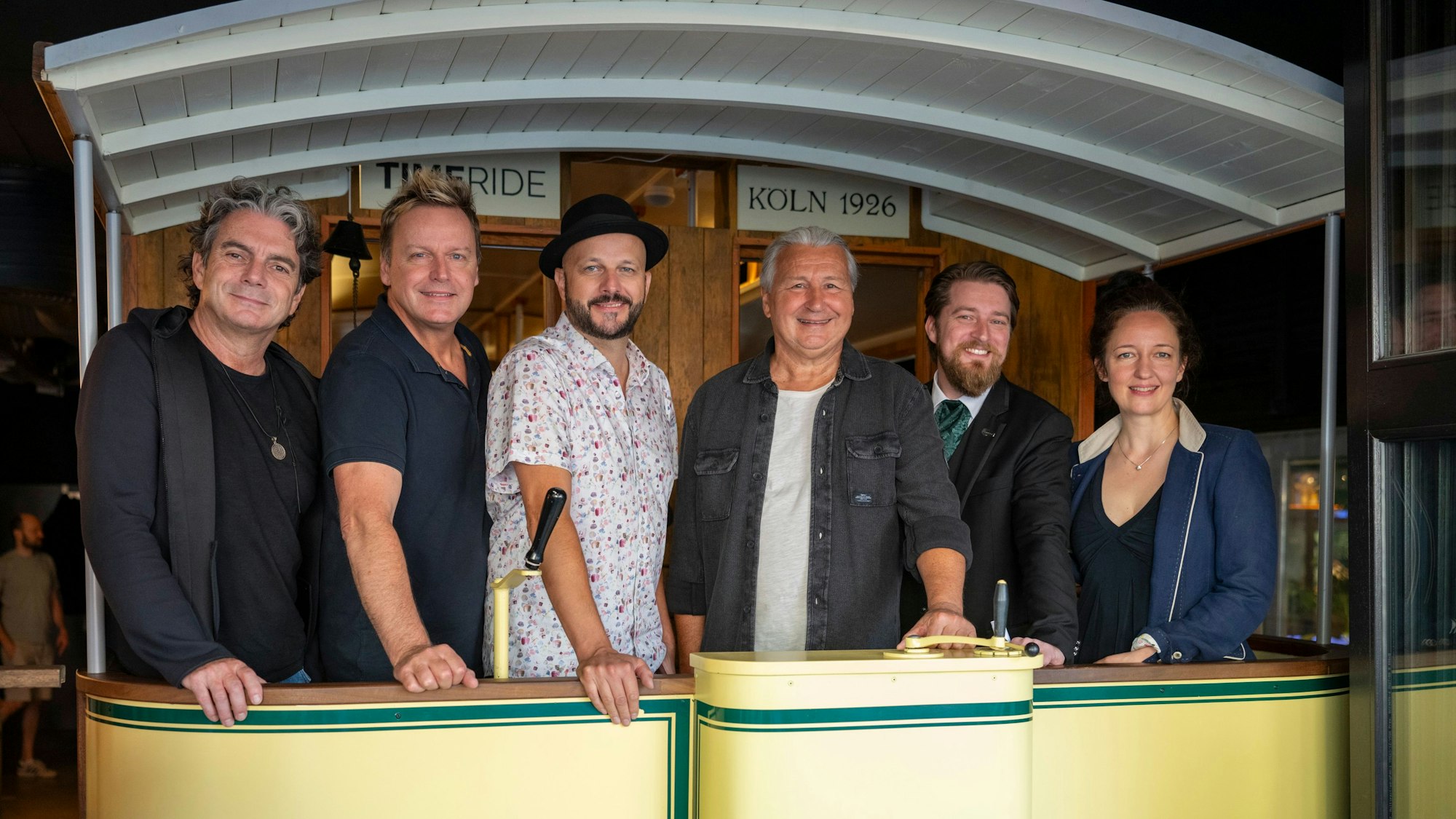Bläck Fööss stehen in einem historisch anmutenden Straßenbahnwaggon von Time Ride Köln.