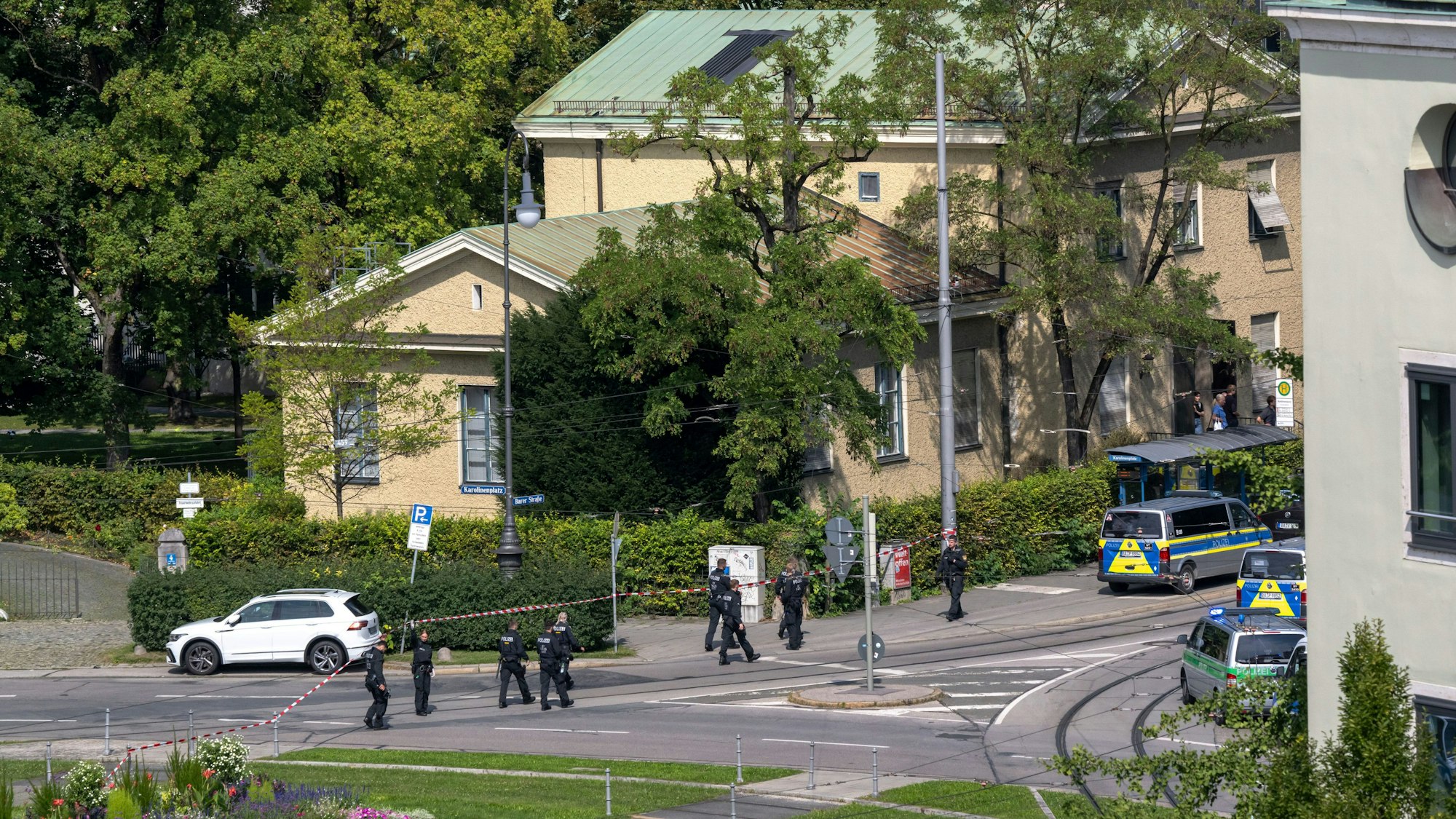 Polizisten gehen eine Straße am Karolinenplatz auf der Suche nach Spuren ab. Die Polizei hat in der Münchner Innenstadt bei einem größeren Einsatz in der Nähe des Israelischen Generalkonsulats eine verdächtige Person niedergeschossen.