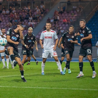 FC-Nachwuchsmann Etienne Borie versucht, den Ball volley zu nehmen, doch Serhat-Semih Güler von Viktoria Köln blockt den Schuss.