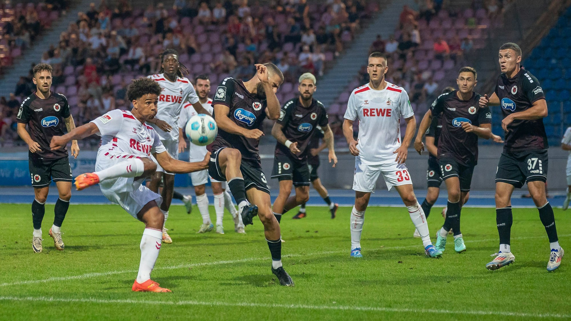 FC-Nachwuchsmann Etienne Borie versucht, den Ball volley zu nehmen, doch Serhat-Semih Güler von Viktoria Köln blockt den Schuss.