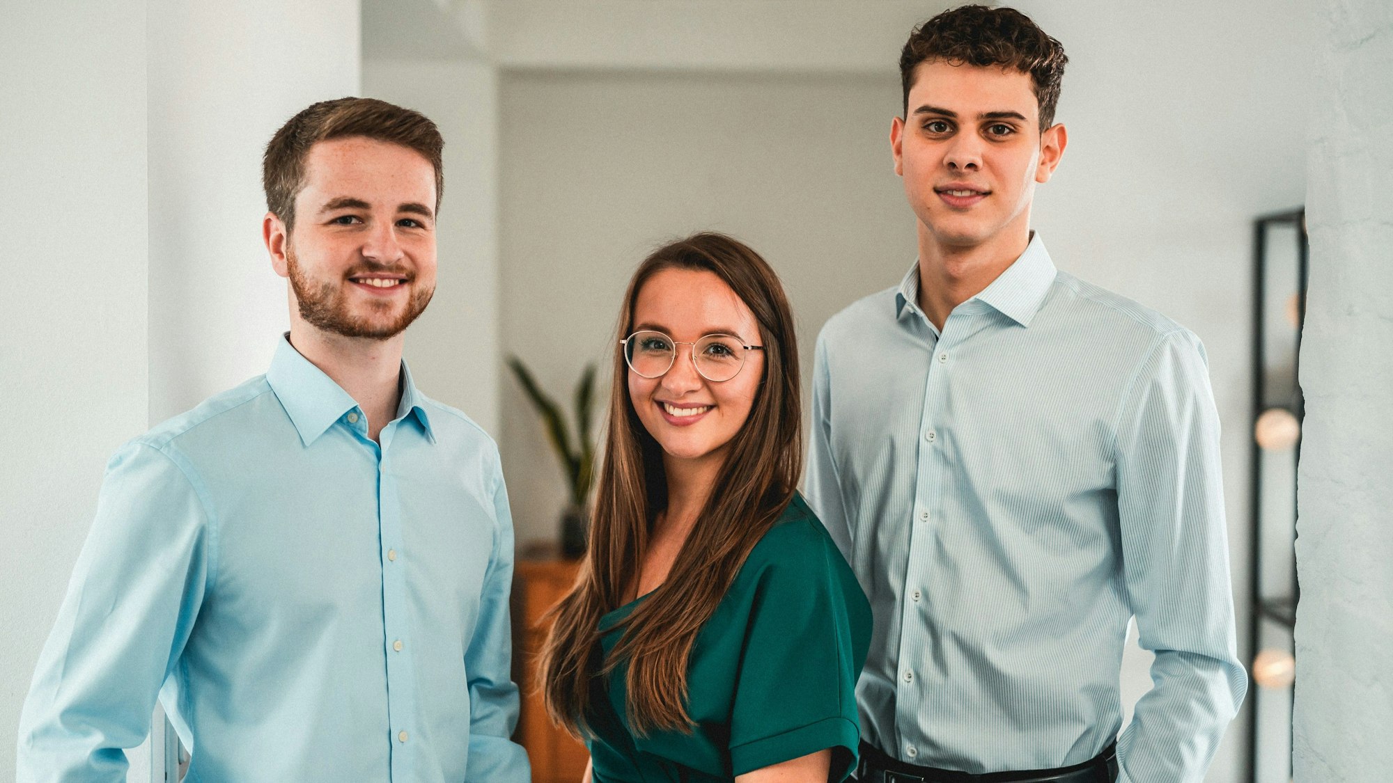 Zu sehen sind zwei junge Männer und eine junge Frau (Mitte).