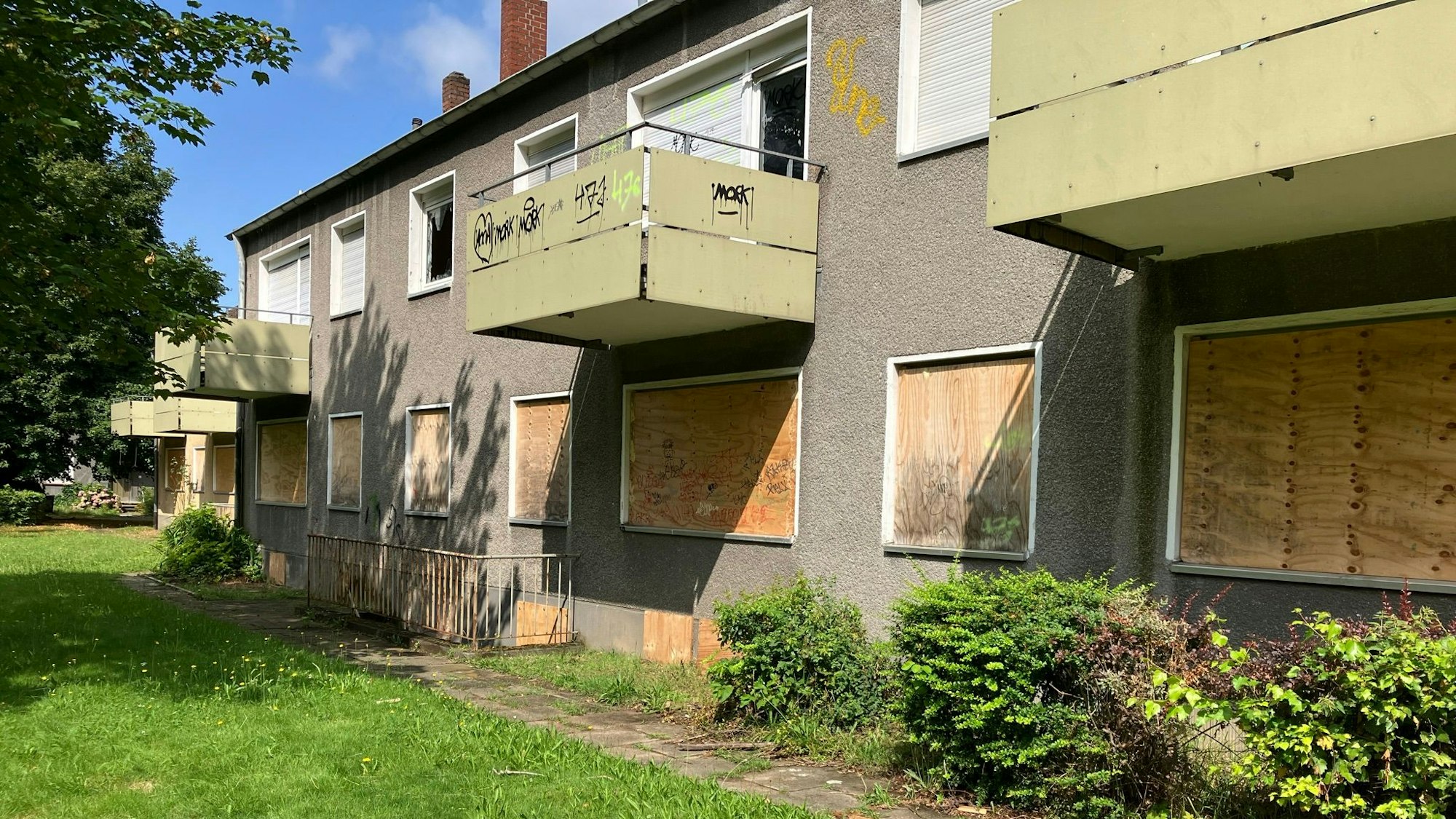 Zu sehen sind leerstehende Wohnhäuser, mit verbretterten Fenstern und Türen.