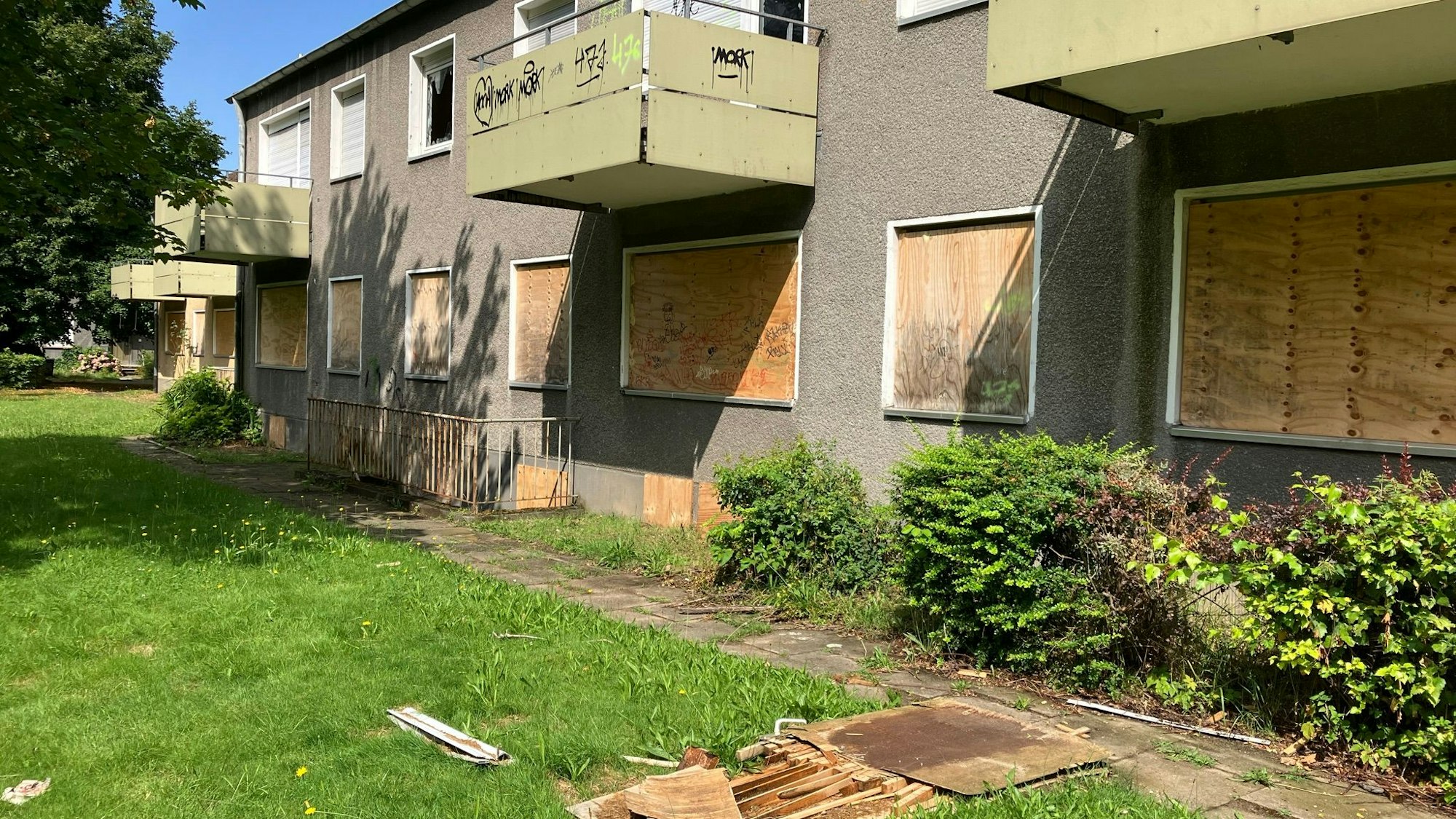 Blick auf einen Wohnblock mit Wohnungen, deren Fenster verrammelt sind.