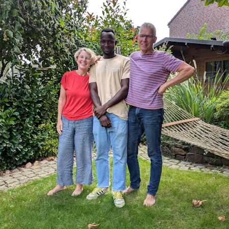 Drei Leute stehen auf einem Rasen.