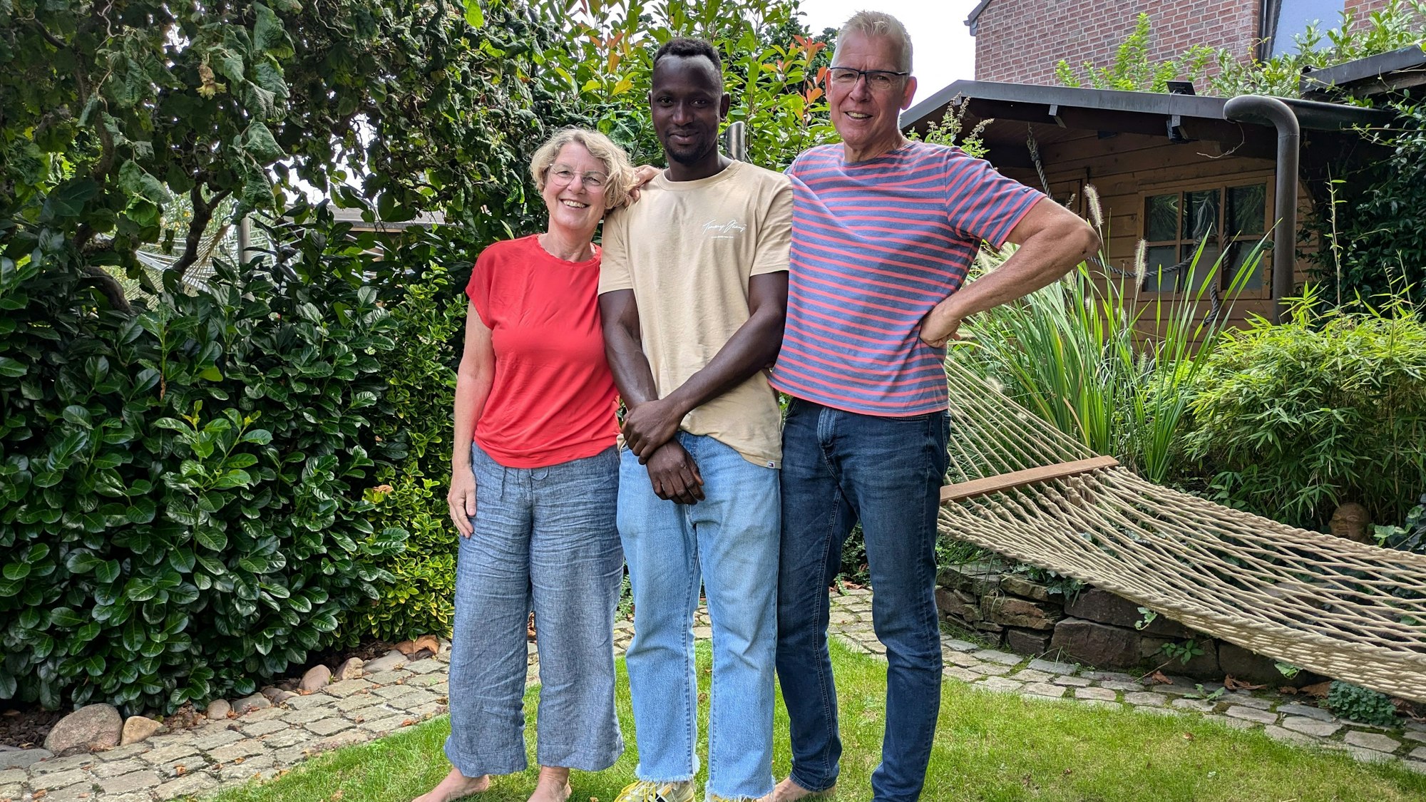 Drei Leute stehen auf einem Rasen.