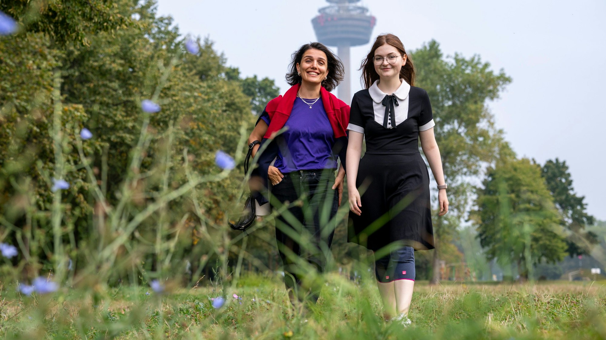 Elene Shubladze und Felicitas Mack spazieren in Köln über eine Wiese.