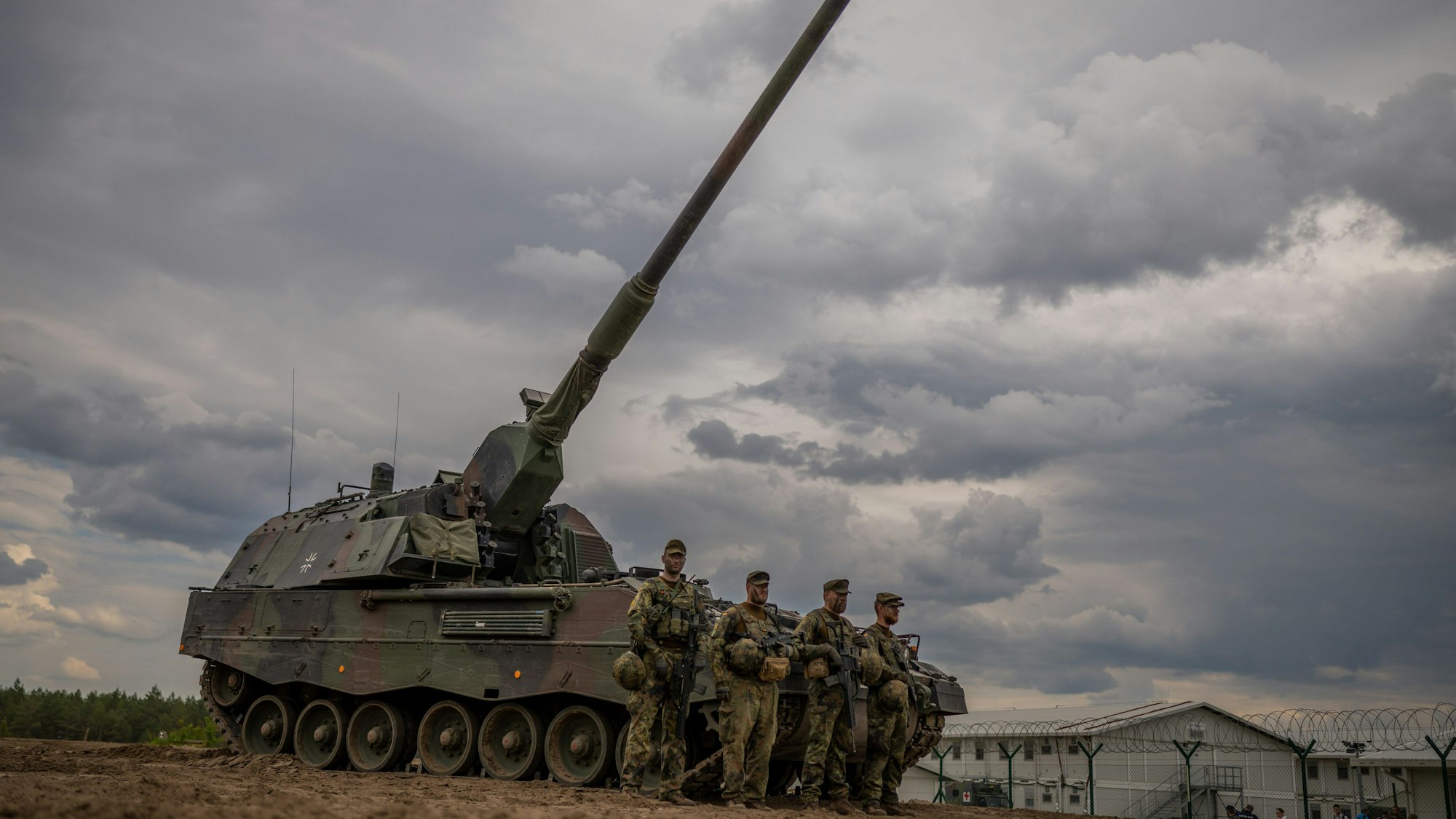 Soldaten stehen vor einem gepanzerten, selbstfahrenden Artilleriegeschütz vom Typ Panzerhaubitze 2000 der Bundeswehr (Symbolbild).