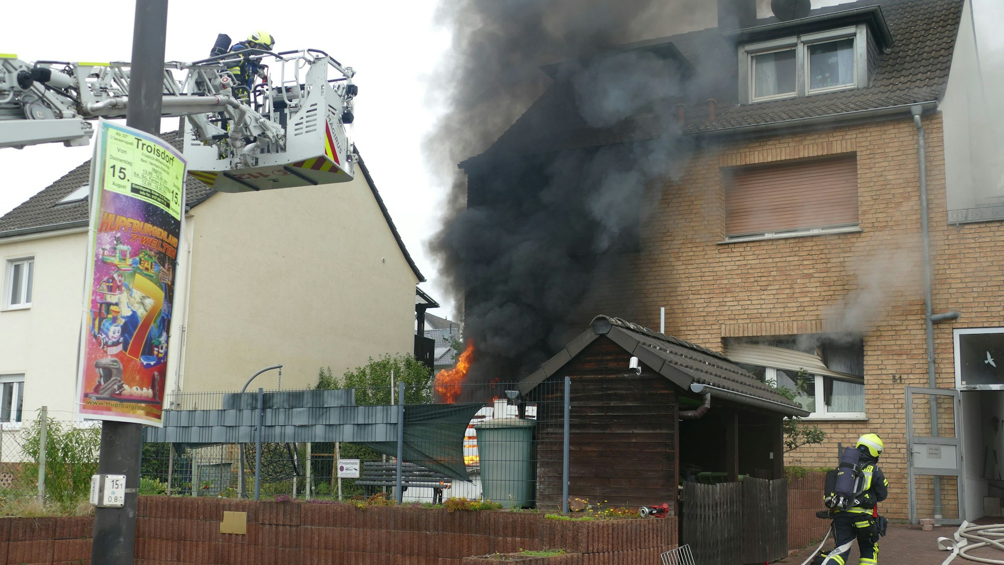 Eine Rauchsäule steigt vor einem Haus auf.