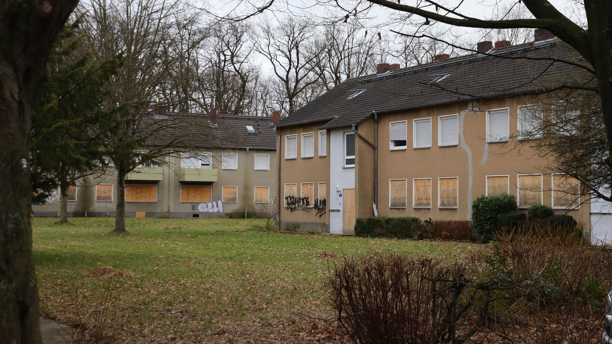 Zu sehen sind leerstehende Wohnhäuser, mit verbretterten Fenstern und Türen.