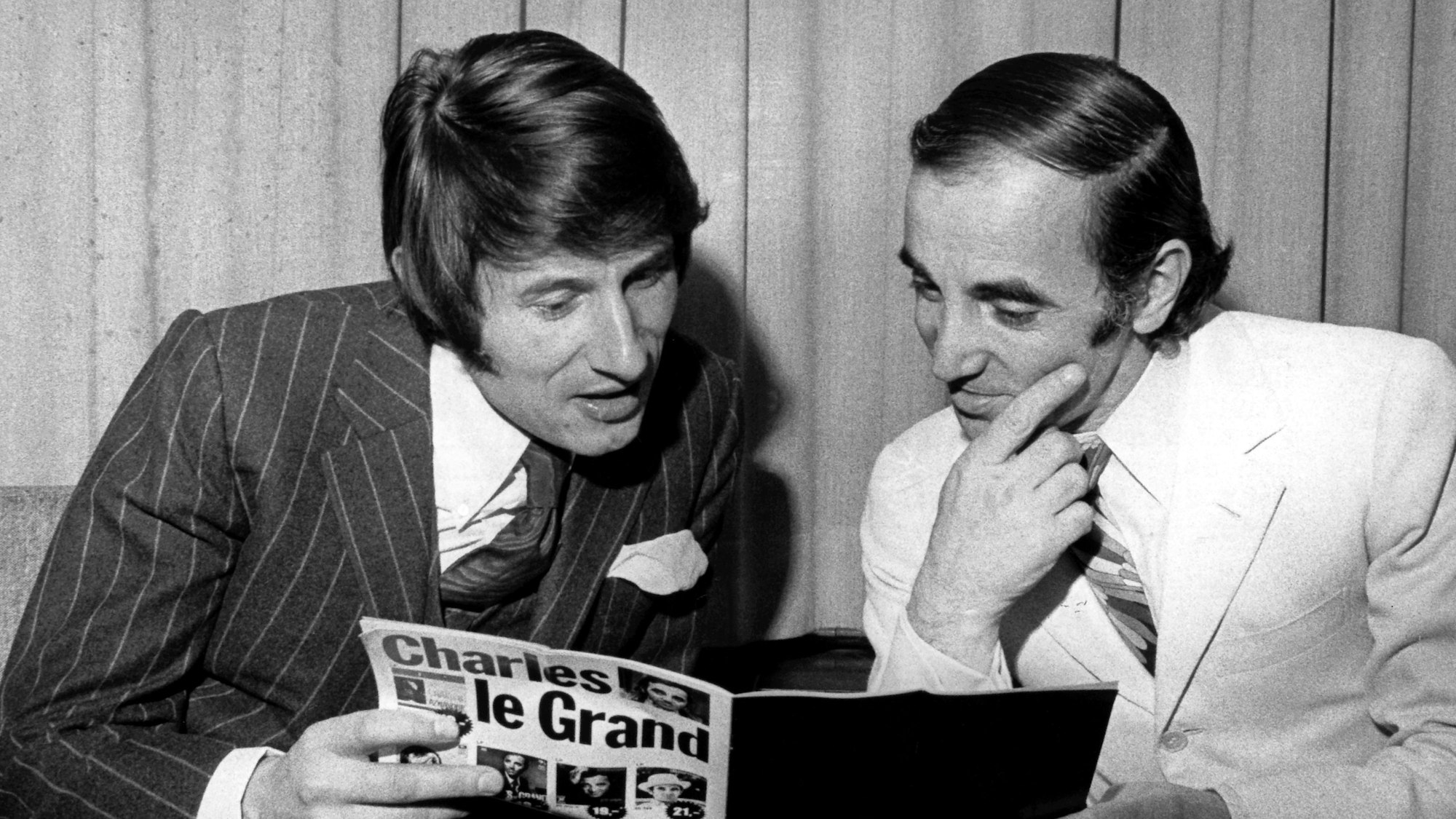 Der französische Sänger Charles Aznavour und Udo Jürgens lesen während einer Konzertpause das Programmheft von Aznavour.