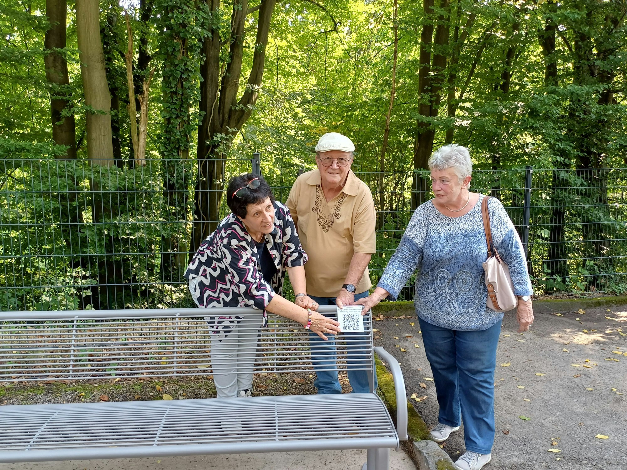 Axel Riemscheid (Mitte) spendete die Bank, an der der QR-Code angebracht wurde.
