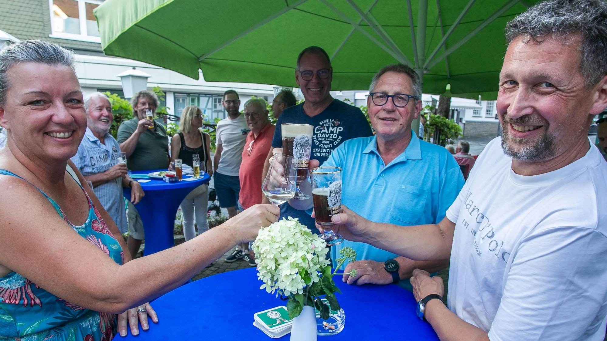 Bernd-Uwe Mach (Mitte) ist seit dem Beginn Vorsitzender der Genossenschaft hinter dem Café und Bistro „Hauderei“ in Waldbröl. Hier feiert er vor einem Jahr mit ersten Gästen die Eröffnung des Gastro-Betriebs an der Hochstraße.