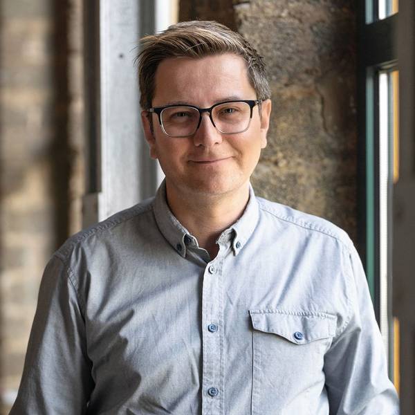 Der SPD-Politiker trägt eine Brille und ein graues Hemd.