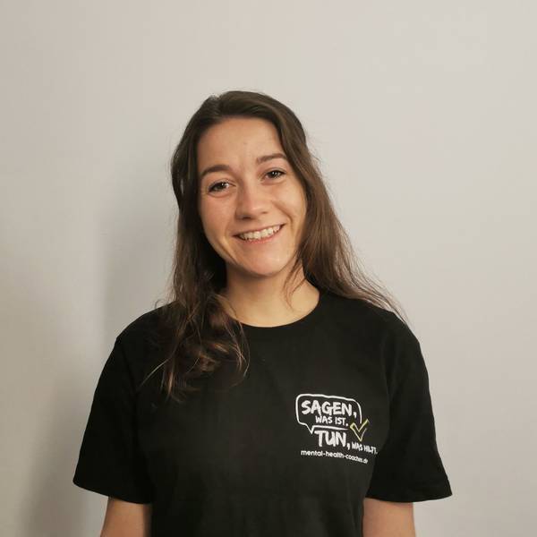 Zu sehen ist eine Frau mit dunklen langen Haaren in einem schwarzen T-Shirt.