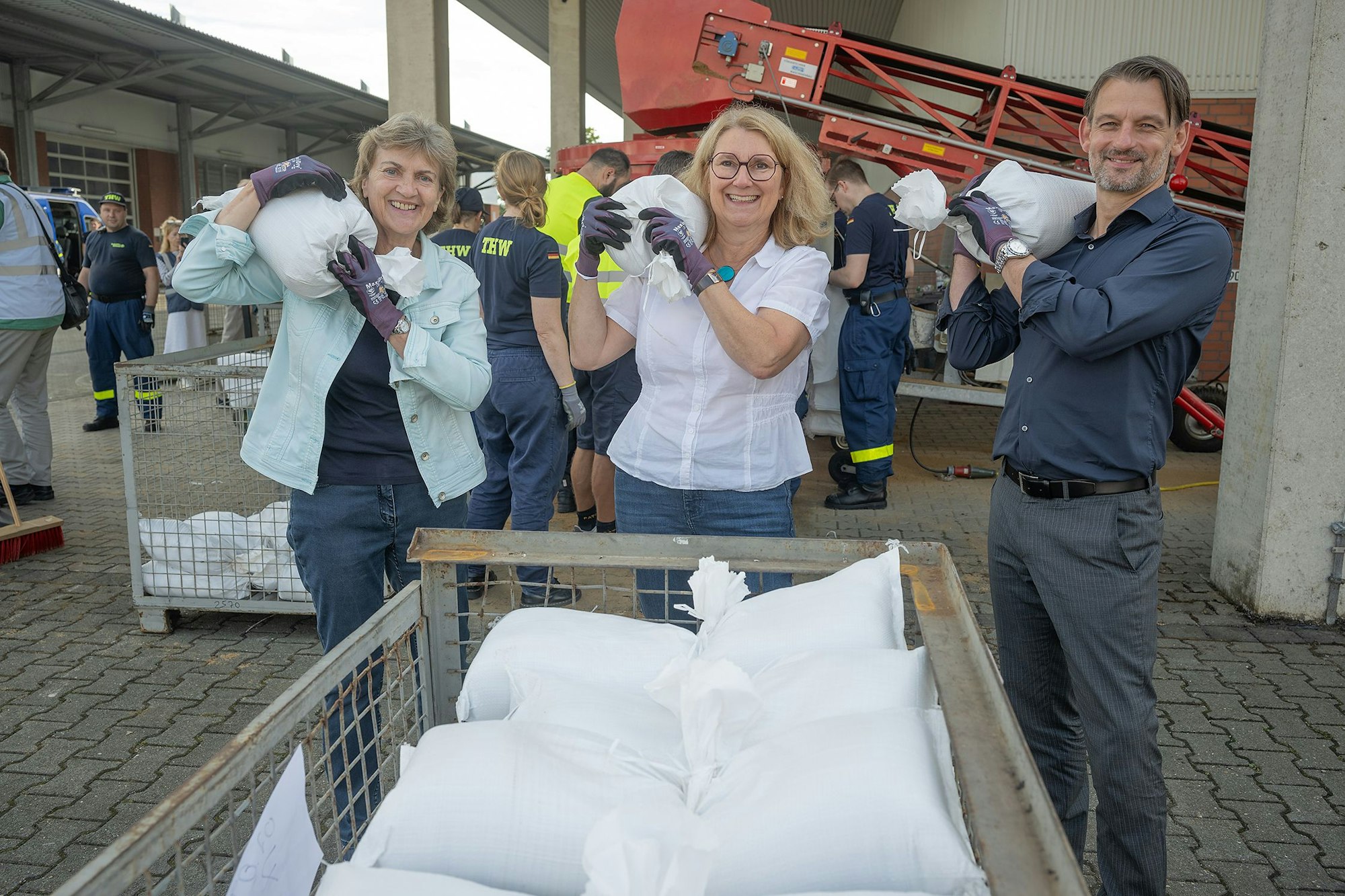 Von der Sandsackfüllaktion mit Freiwilligen verschafften sich auf dem Werksgelände der Steb Köln in Merheim Kalks Bezirksbürgermeisterin Claudia Greven-Thürmer (links), Ulrike Franzke vom Vorstand der Steb und William Wolfgramm, Dezernent für Klima, Umwelt, Grün und Liegenschaften der Stadt Köln, einen persönlichen Eindruck.