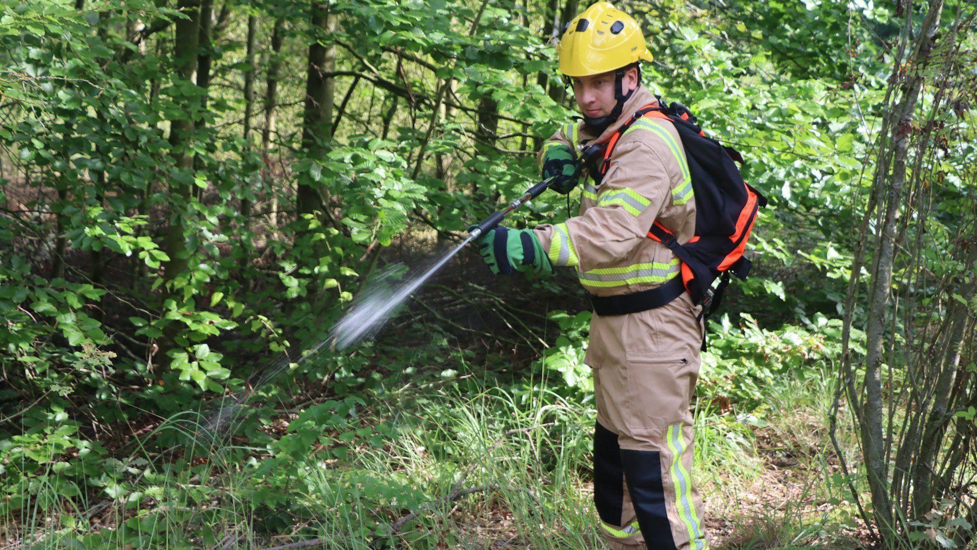 Ein Feuerwehrmann löscht einen Brand.