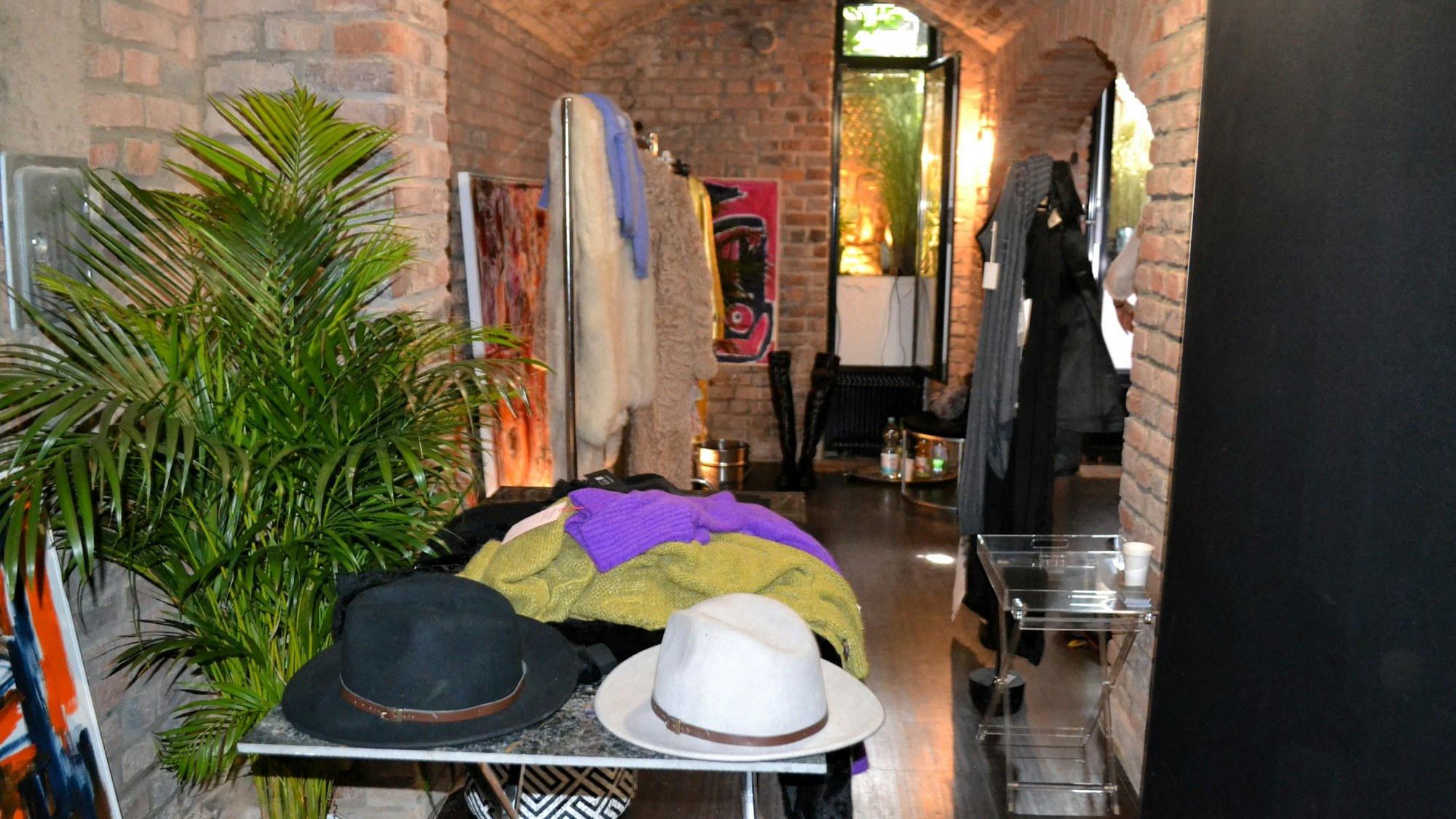 Blick in einen Gewölbekeller. Auf einem Tisch liegen Hüte.