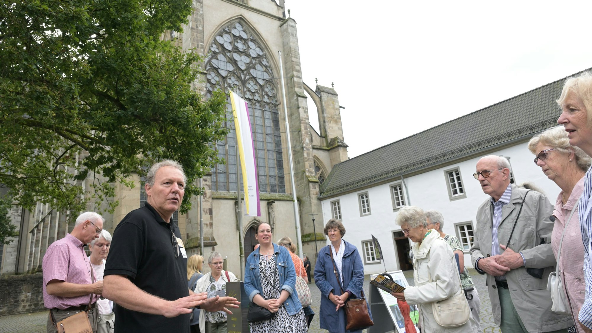 Randolf Link mit einer Besuchergruppe vor dem Altenberger Dom. Westportal.