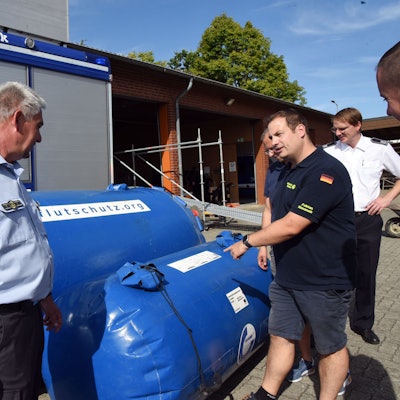 Mit solchen Rollen stoppt das Technische Hilfswerk Flutwasser. Torsten Simon (links), Ortsbeauftragter des THW für Gummersbach, erklärt, wie diese mobilen Barrieren funktionieren.