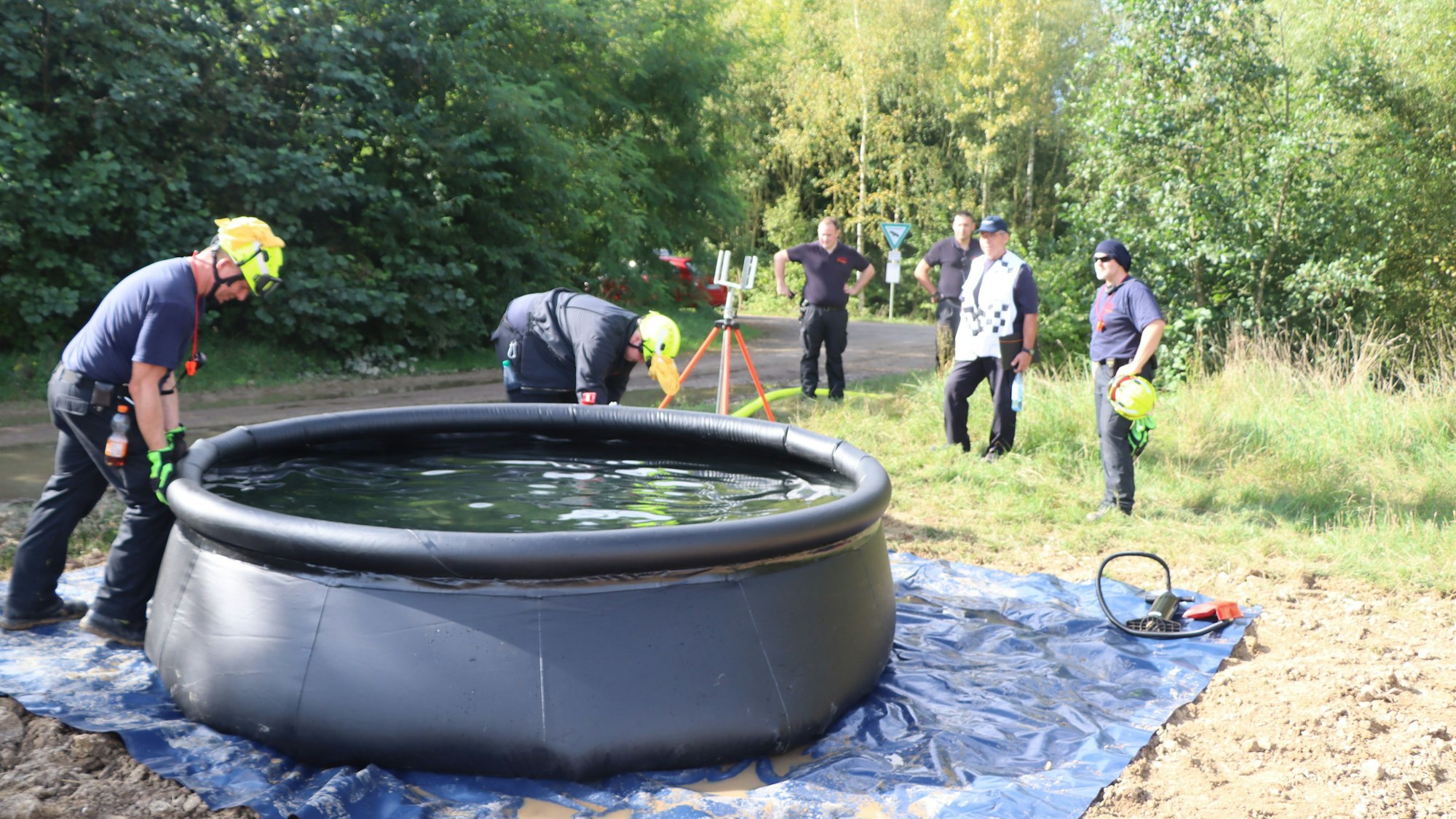 Feuerwehrleute bauen einen Wasserbehälter mit einem Fassungsvermögen von 5000 Liter auf.