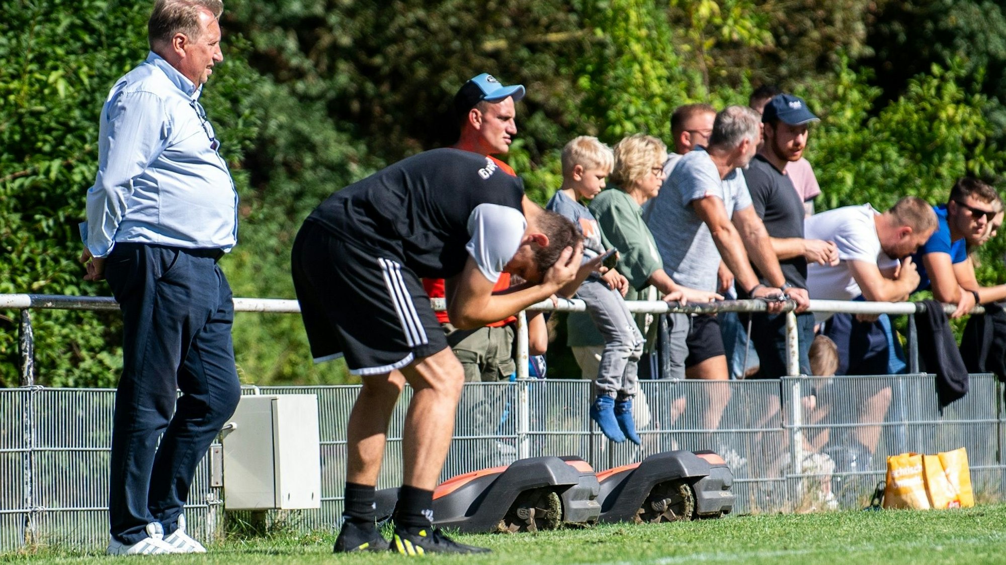 Frauenbergs Trainer beugt sich nach vorne und begräbt den Kopf in seinen Armen.