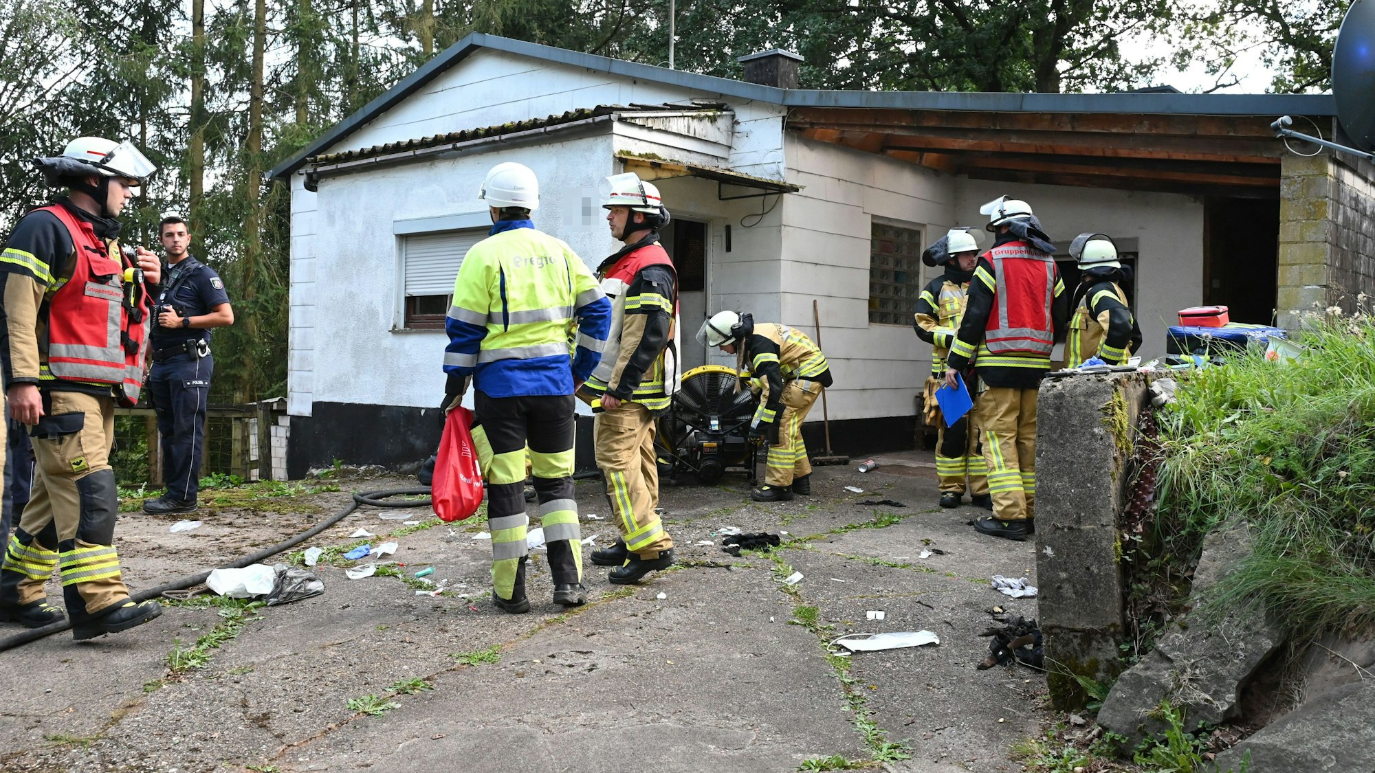 Zahlreiche Feuerwehrleute stehen vor einem Haus in Kall-Golbach.