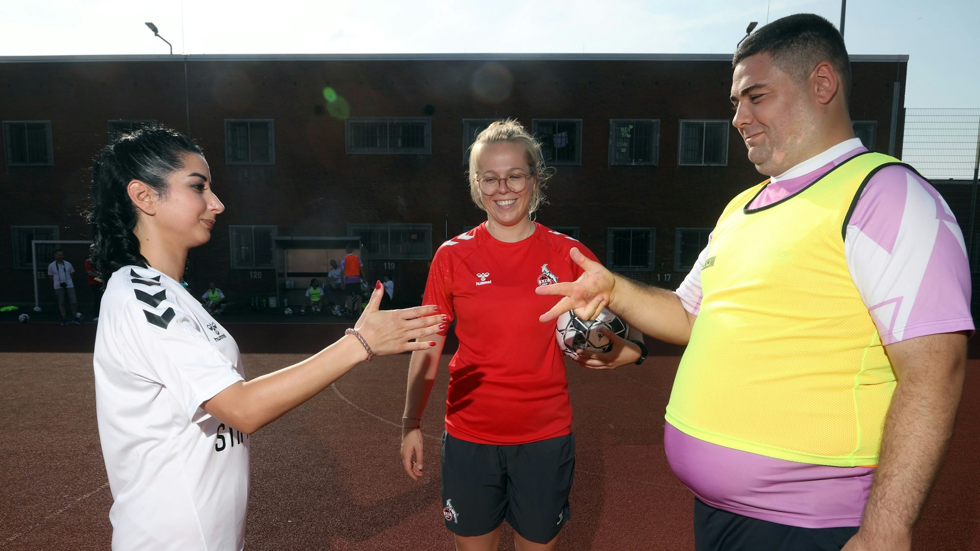 Eine Runde Schere, Stein, Papier klärt die Frage nach dem Anstoß zwischen einer Insässin der JVA (links) und einem Spieler der Inklusionsmannschaft von Germania Zündorf, Trainerin Luisa Schanze (FC-Stiftung) kontrolliert.