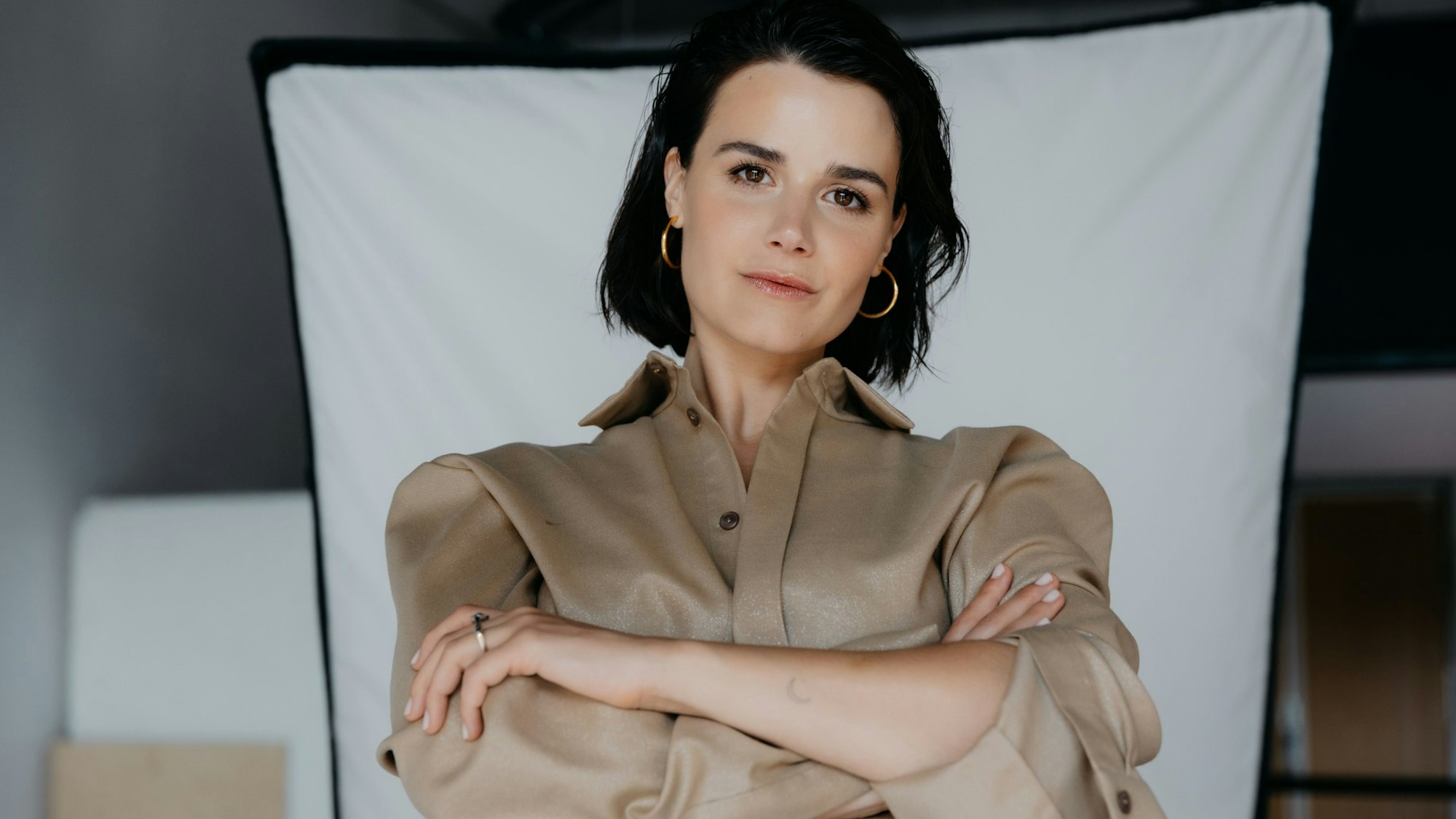 Die Journalistin und Fernsehmoderatorin Yara Hoffmann schaut mit verschränkten Armen in die Kamera.