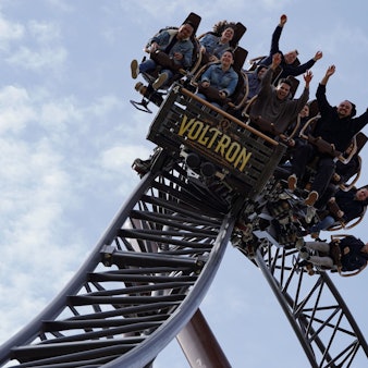 Menschen sitzen in der neuen Voltron-Achterbahn des Europa-Parks.