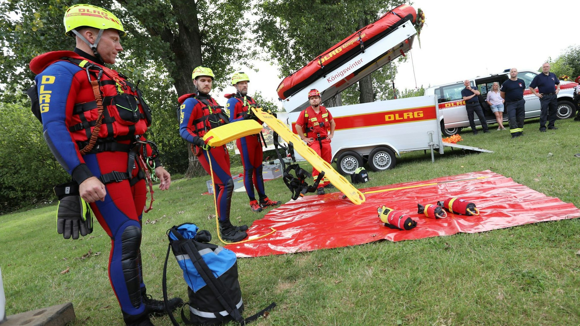 Männer in Neoprenanzügen und gelben Helmen.