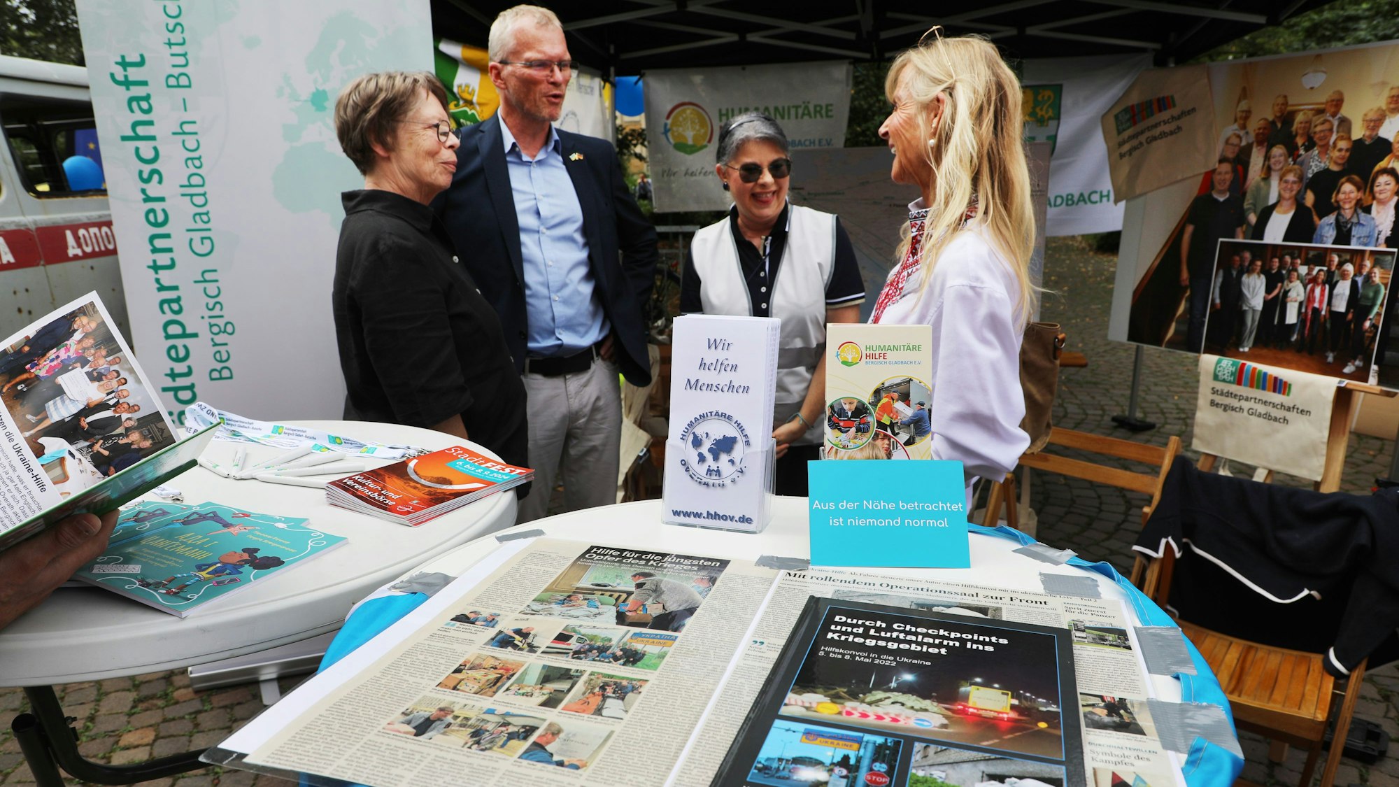 Bürgermeister Frank Stein steht im Gespräch am Stand des Vereins zur Förderung der Städtepartnerschaft Bergisch Gladbach – Butscha, der beim Stadtfest für eine Spendensammelaktion mit der Humanitären Hilfe Bergisch Gladbach und Overath kooperierte.