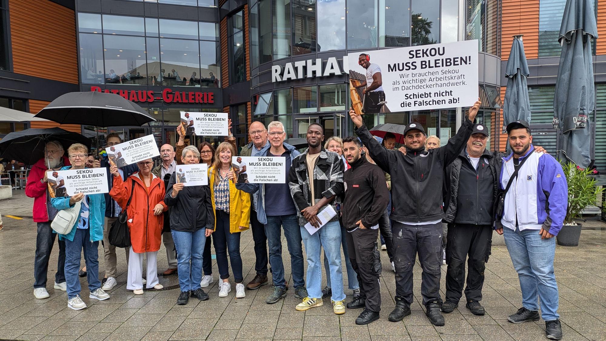Eine Gruppe von Menschen demonstriert vor dem Rathaus in Wiesdorf.
