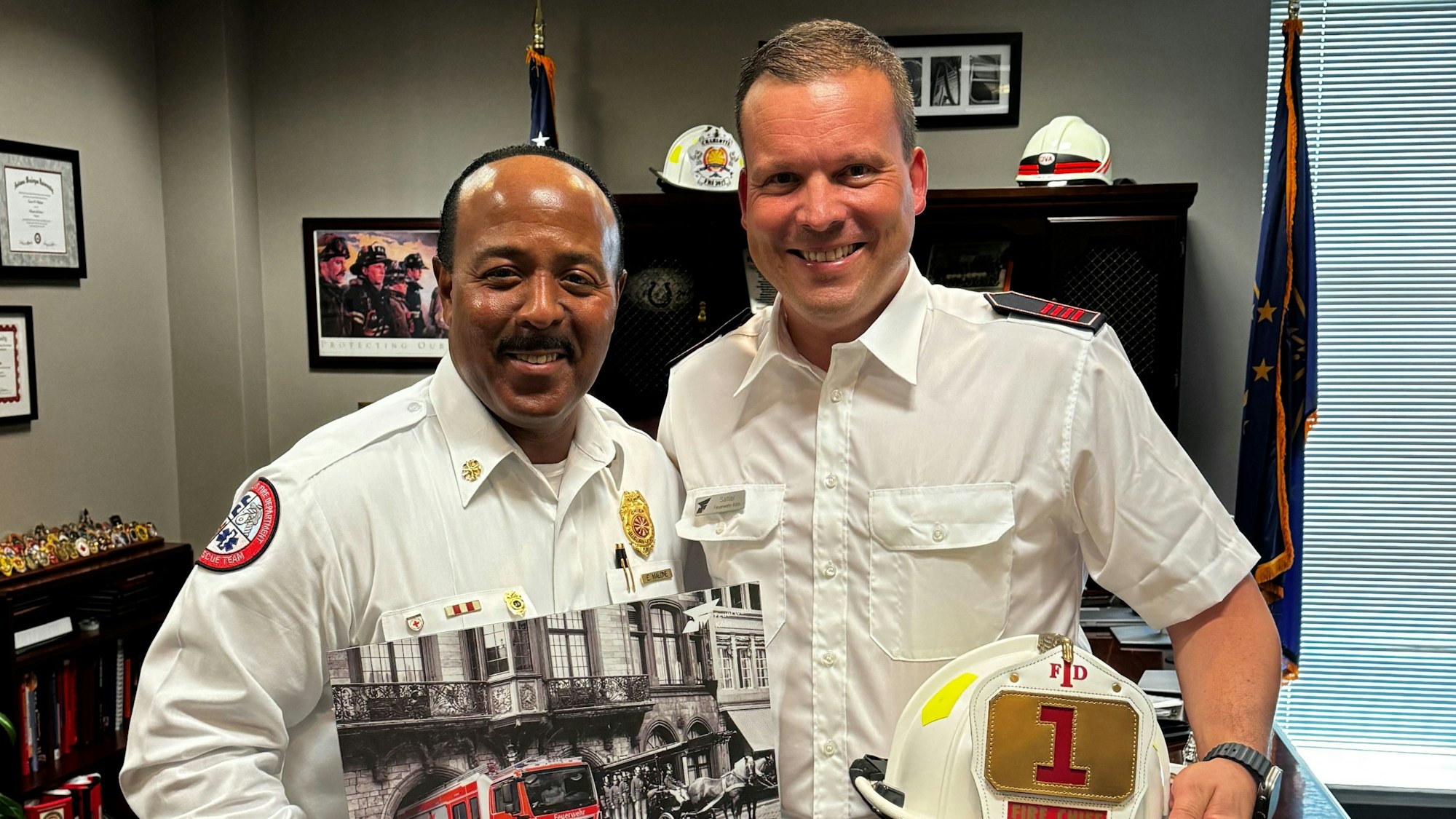 Paul Sattler (r.) mit dem Feuerwehrchef aus Indianapolis, Ernest Malone, beim gegenseitigen Überreichen der Gastgeschenke.