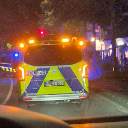 Ein Polizeiauto steht an der Bensberger Straße in Bergisch Gladbach-Heidkamp.