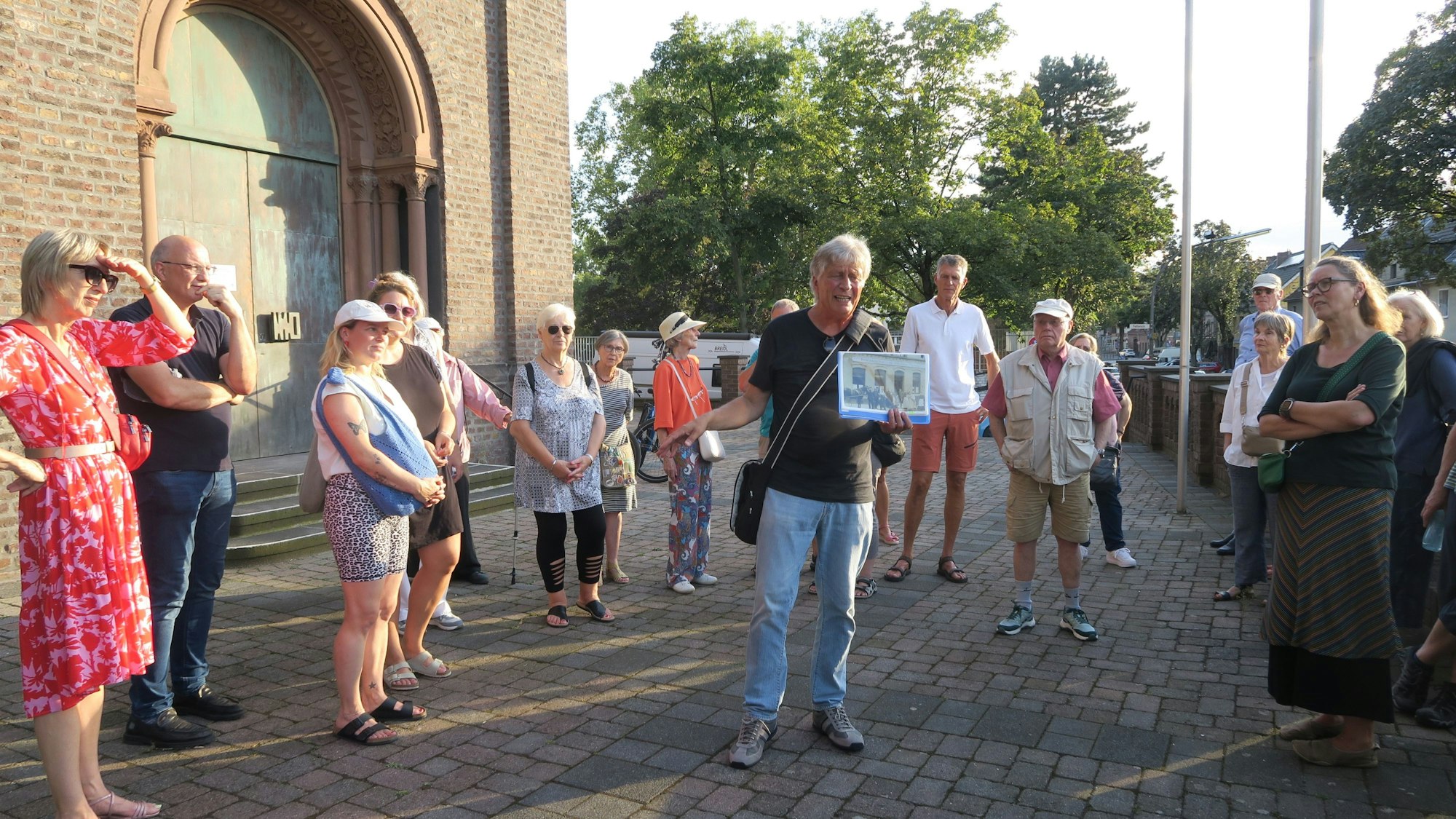 Zu sehen sind Besucher einer Führung vor dem Haupteingang von St. Rochus.