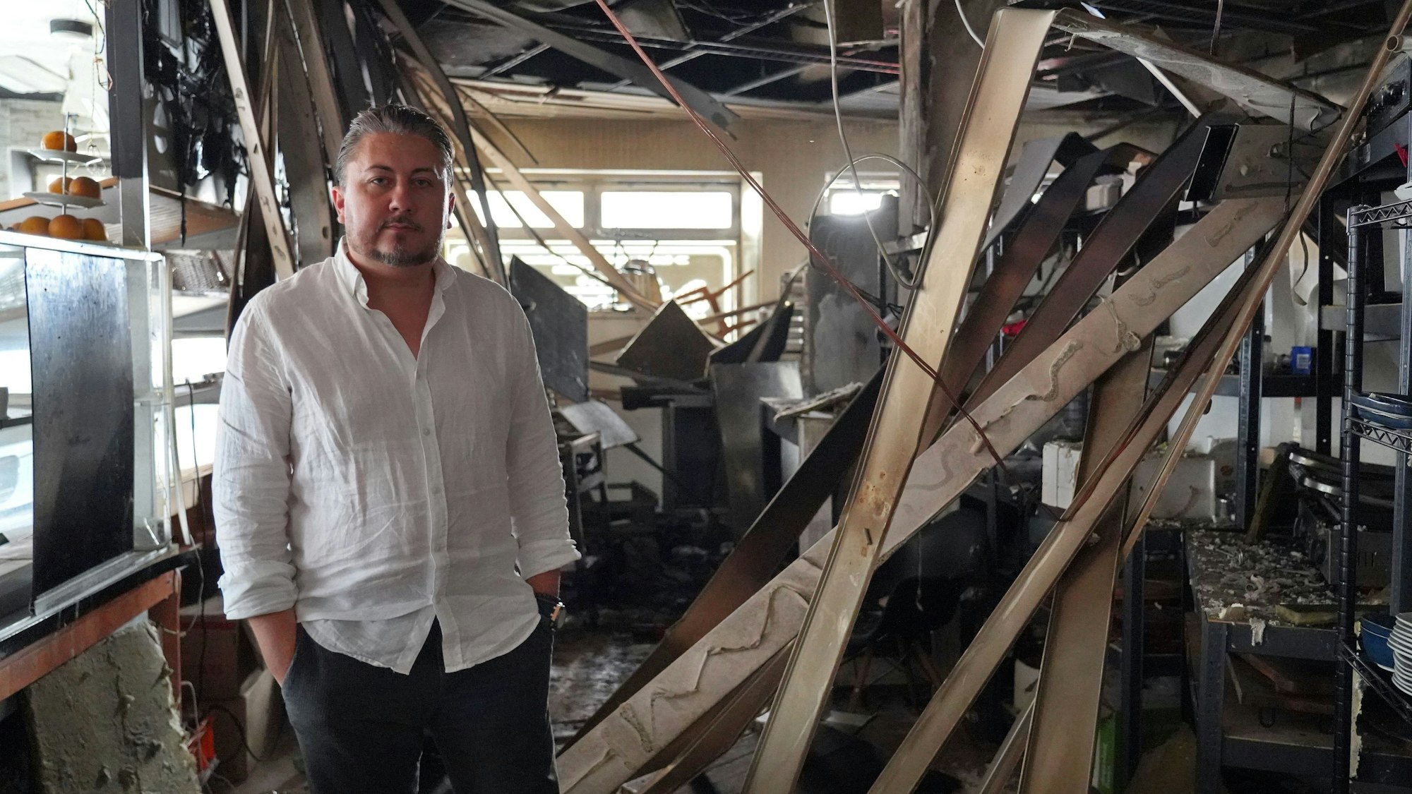 Ein Mann steht in einem zerstörten Innenraum