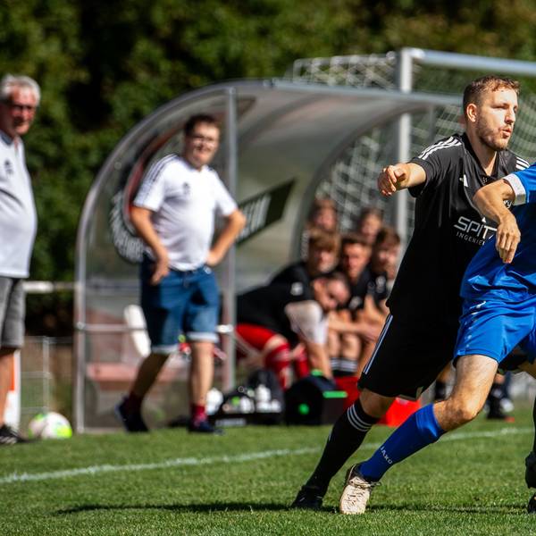 Ein Fußballer balanciert den Ball auf der Nase.