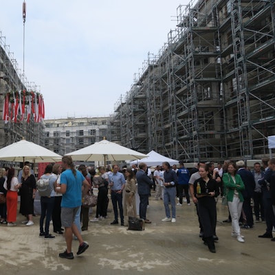 Zu sehen sind Richtfest-Besucher, die inmitten einer Wohnungsbaustelle stehen.