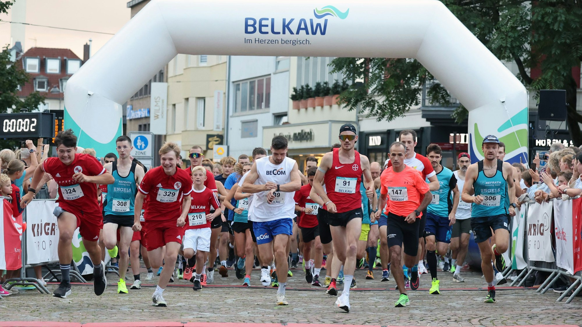 Die Läufer starten unter einem weißen Bogen der Belkaw.