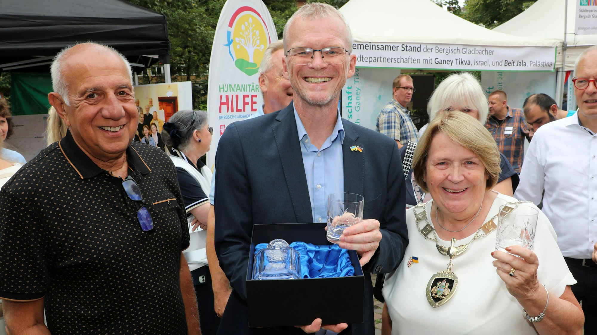 Runnymedes Bürgermeisterin Elaine Gill überreicht Bergisch Gladbachs Bürgermeister Frank Stein beim Stadtfest ein Kristallservice mit Gravur.