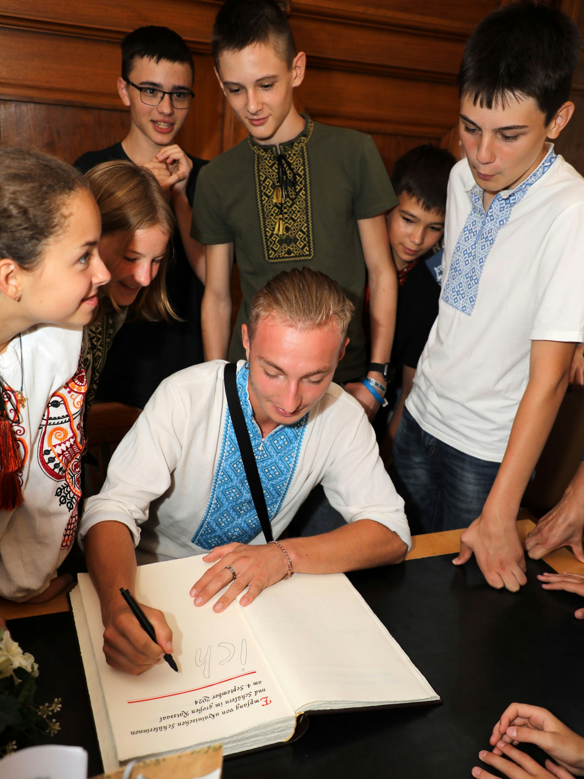 Tolik Rybakov aus Butscha schreibt ins Goldene Buch der Stadt Bergisch Gladbach.