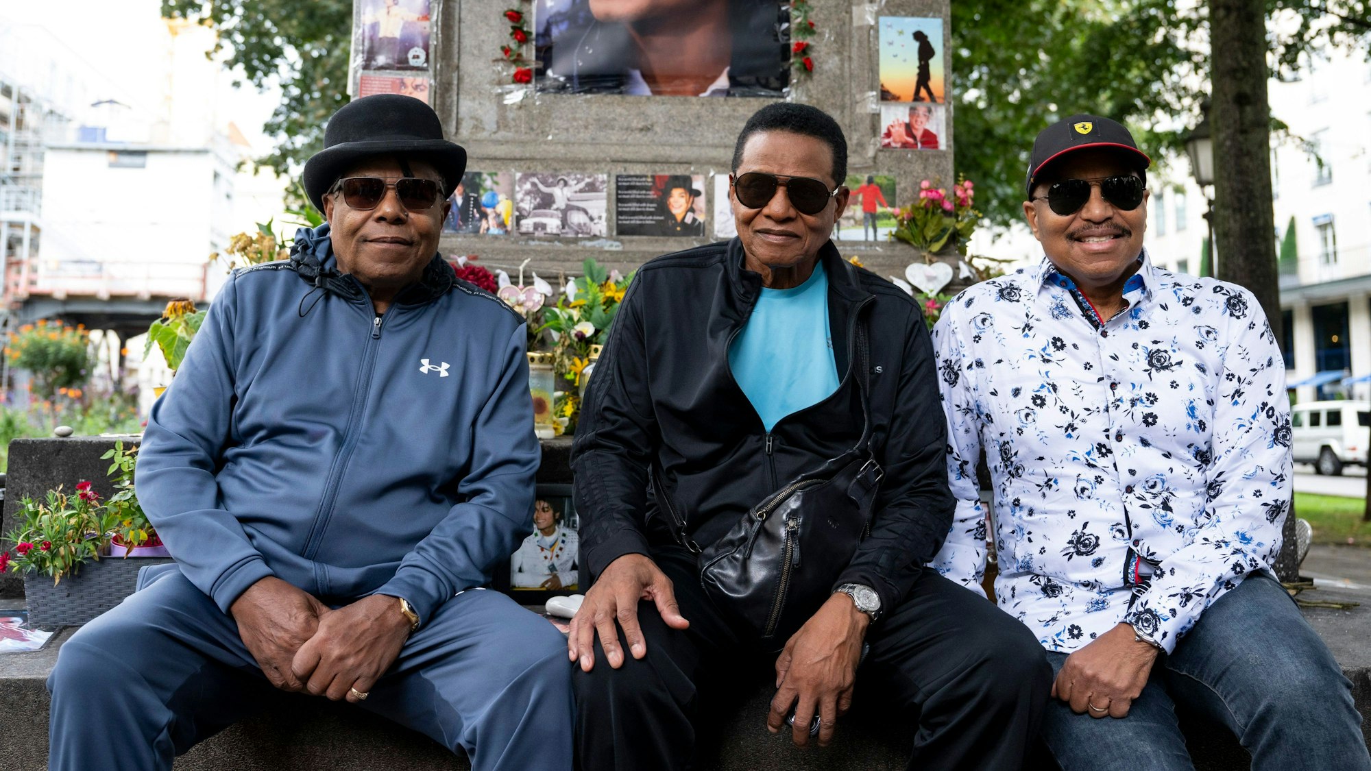 Tito (l-r), Jackie und Marlon Jackson sitzen vor dem Michael Jackson-Denkmal vor dem Hotel Bayerischer Hof.