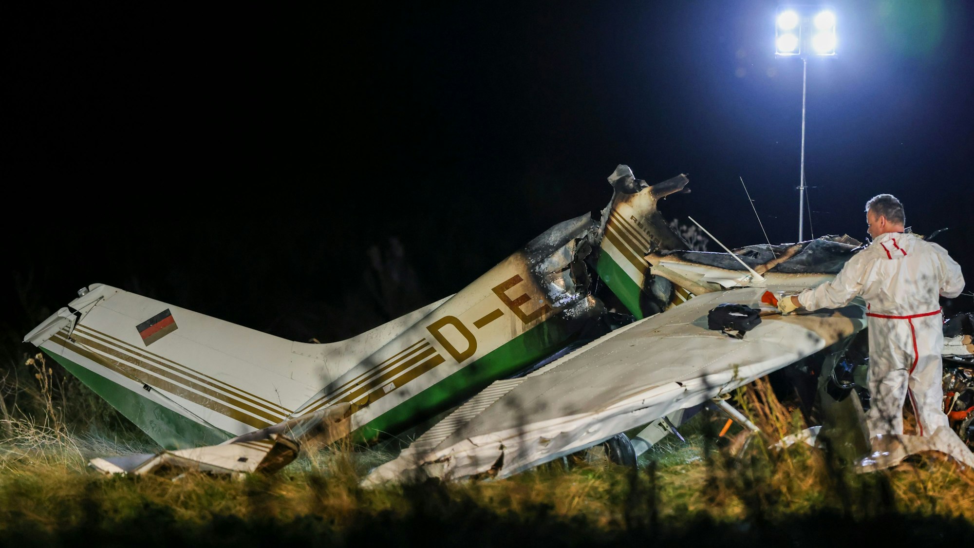 Das Wrack eines Kleinflugzeuges wird auf dem Gelände nahe des Flugplatzes in Bad Sassendorf im Kreis Soest untersucht.