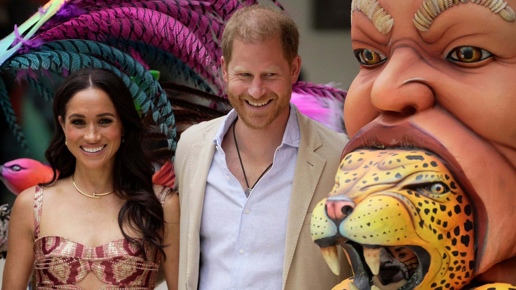 Prinz Harry und Meghan posieren für Fotos mit traditionellen Karnevalstänzern während einer Begrüßungszeremonie in Kolumbien.