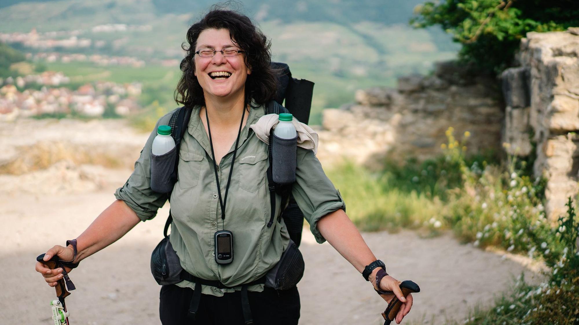 Christine Thürmer lachend mit Wanderstöcken.